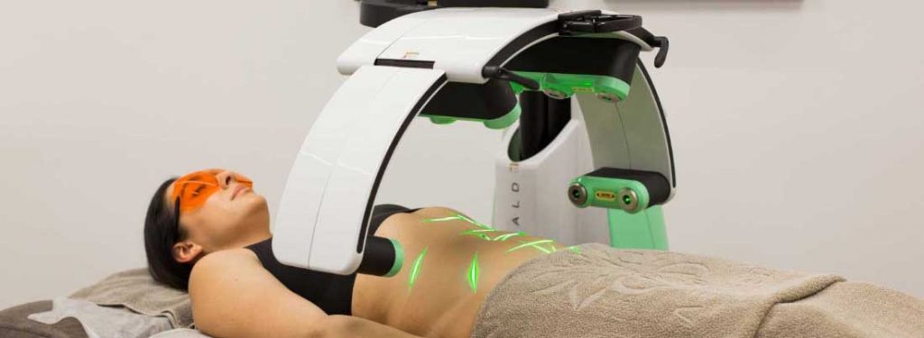 A woman removing stomach fat with a Photobiomodulation Therapy machine for body sculpting