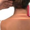 A woman being treated with an LLLT (Low-Level Laser Therapy) device